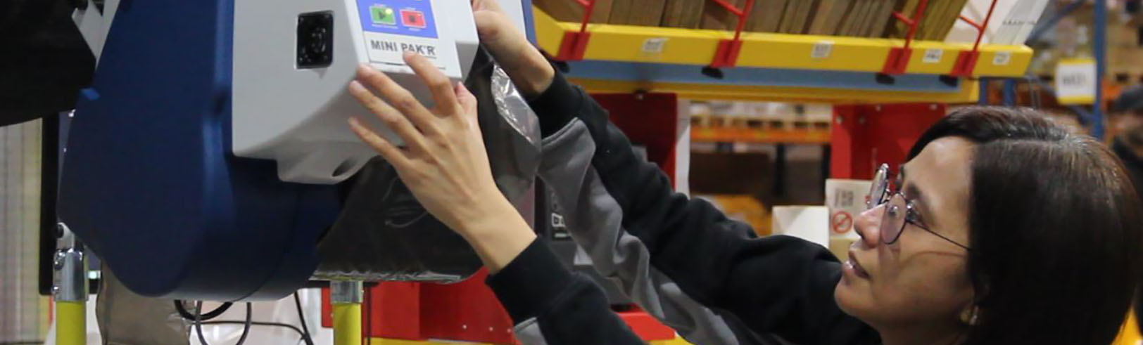 A worker operating the Pregis MINI PAK'R machine
